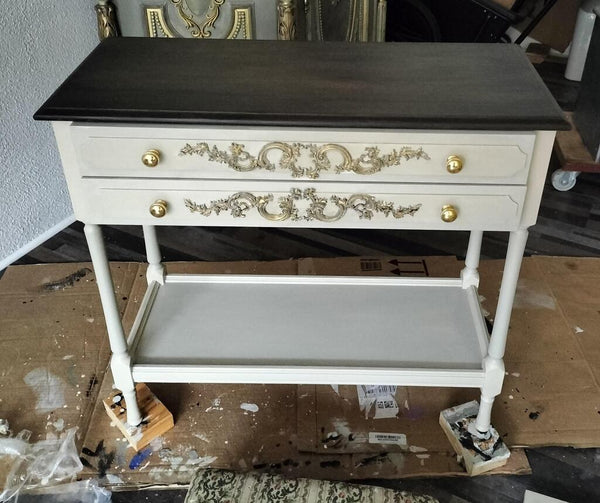 weisser beistelltisch mit ornamenten an den schubladen