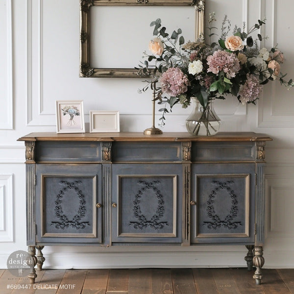 dunkle Kommode mit Verzierungen auf den Türen